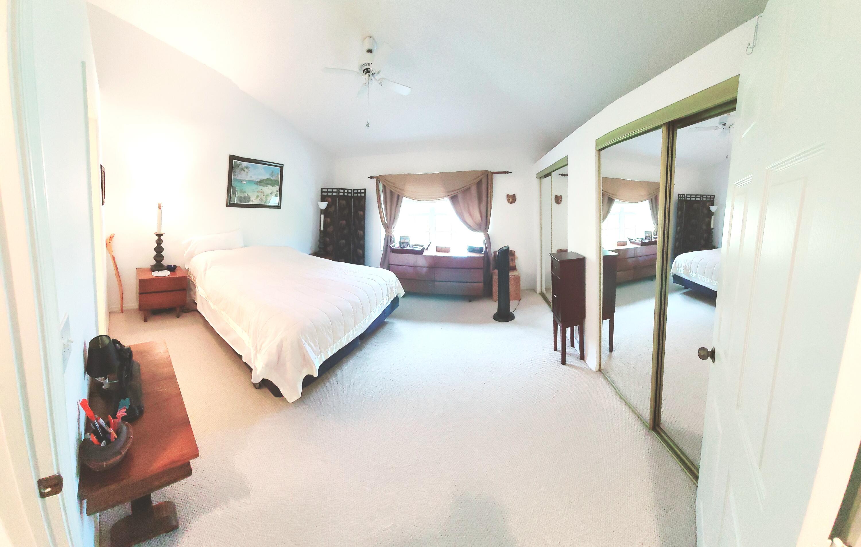5121 Sabal Gardens Lane, Unit 2 Boca Raton, FL 33487 - Photo 14 of 25 a bedroom with a bed and a large mirror