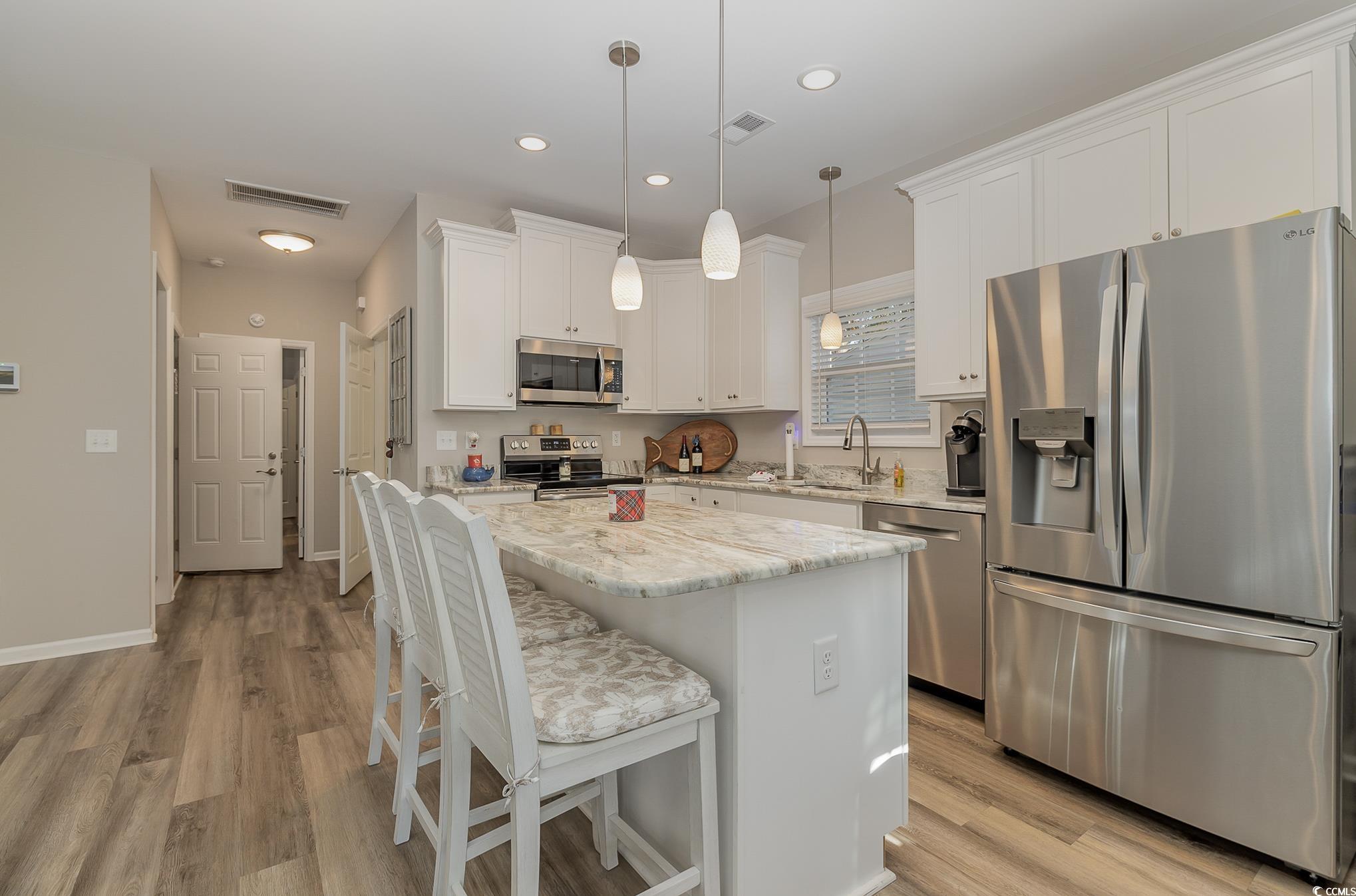 618 Surfside Drive Surfside Beach, SC 29575 - Photo 10 of 40 Kitchen featuring a kitchen island, white cabinets