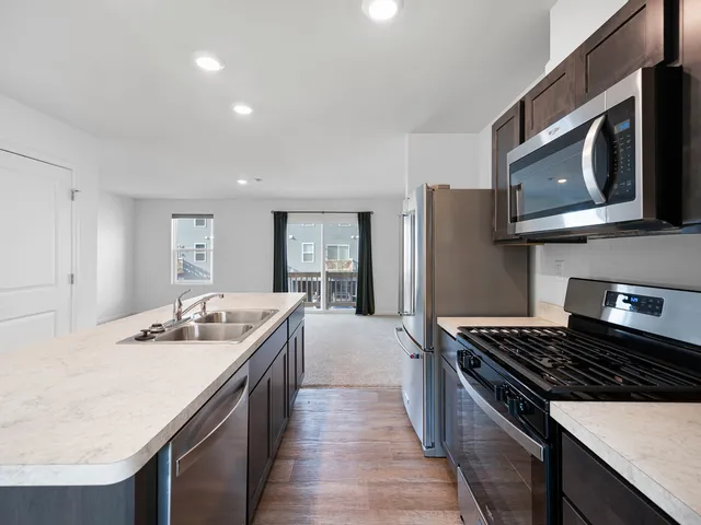 a kitchen with stainless steel appliances granite countertop a sink stove and refrigerator