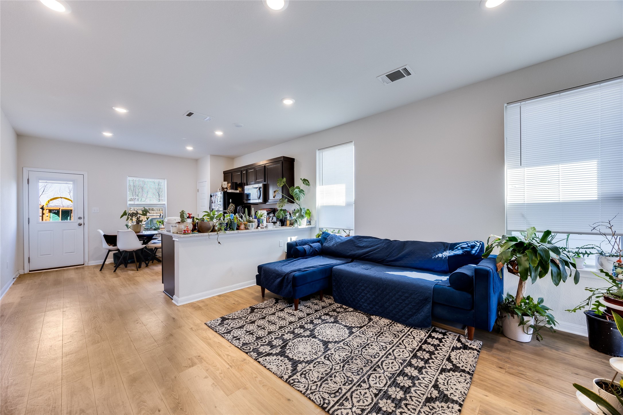 Living area with light wood-style floors and recessed lighting