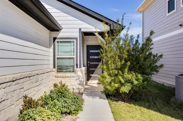 a yellow house with flower garden in front of it