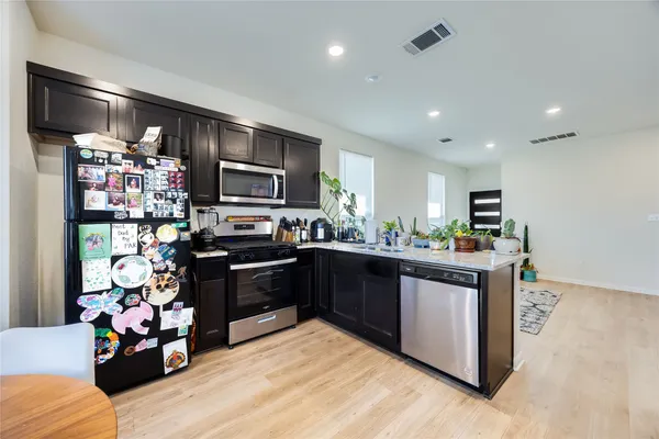 a kitchen with stainless steel appliances kitchen island granite countertop a refrigerator and a stove top oven