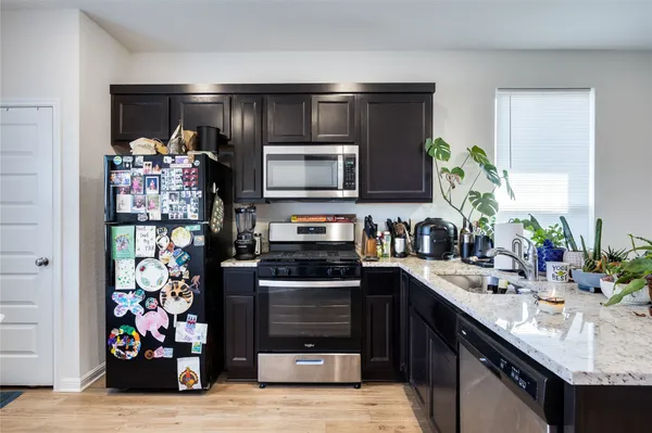 a kitchen with stainless steel appliances kitchen island granite countertop a refrigerator and a stove top oven