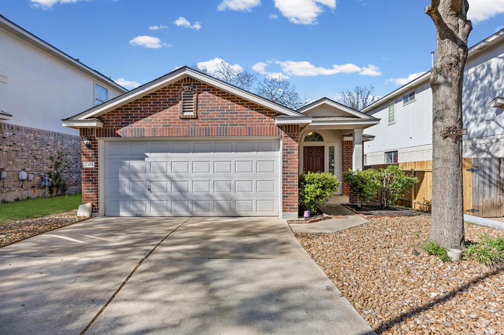Single story home with brick siding, concrete driveway, and an attached garage