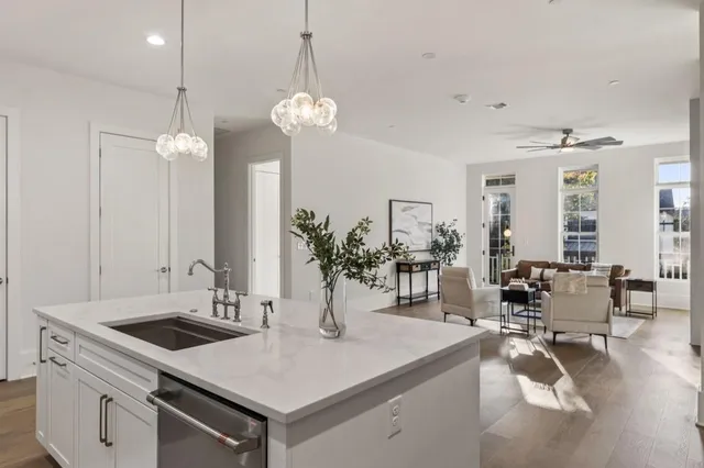 a kitchen with kitchen island granite countertop a sink a stove and cabinets