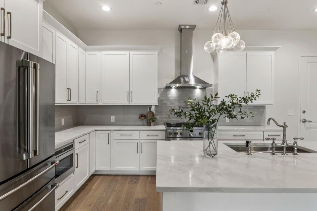 12455 Broadwell Road, Unit 202 Milton, GA 30004 - Photo 14 of 31 a kitchen with kitchen island granite countertop a sink a stove and cabinets