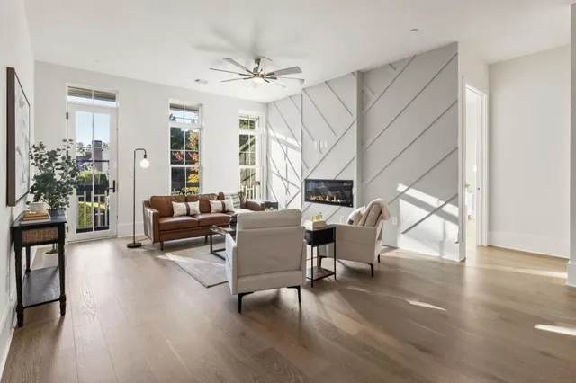 a living room with furniture a wooden floor and next to a window