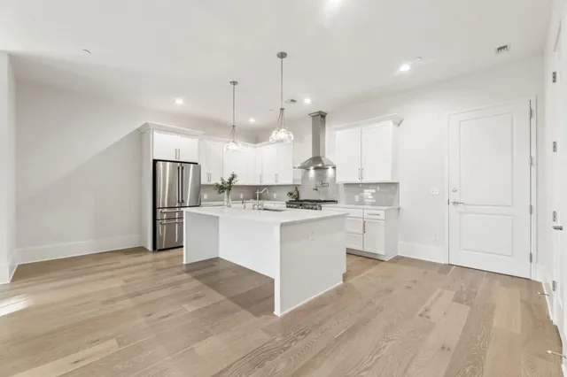 a kitchen with white cabinets and refrigerator