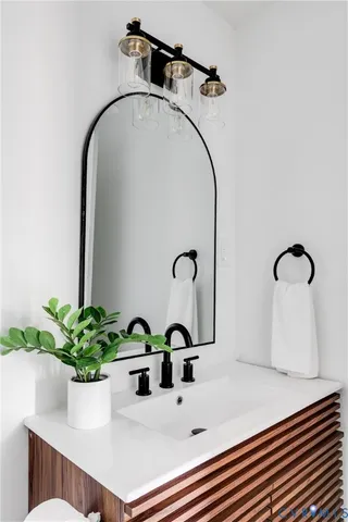 a bedroom with a bed and a chair with painting on the wall