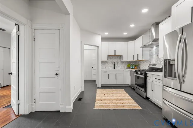 a kitchen with white cabinets and stainless steel appliances