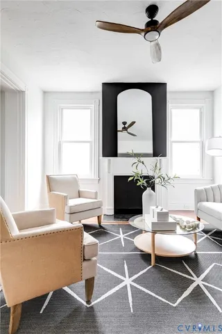 a living room with furniture a flat screen tv and a fireplace