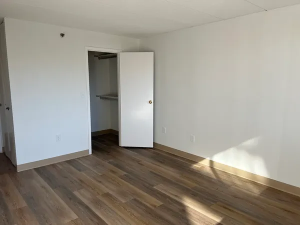 a view of an empty room with wooden floor