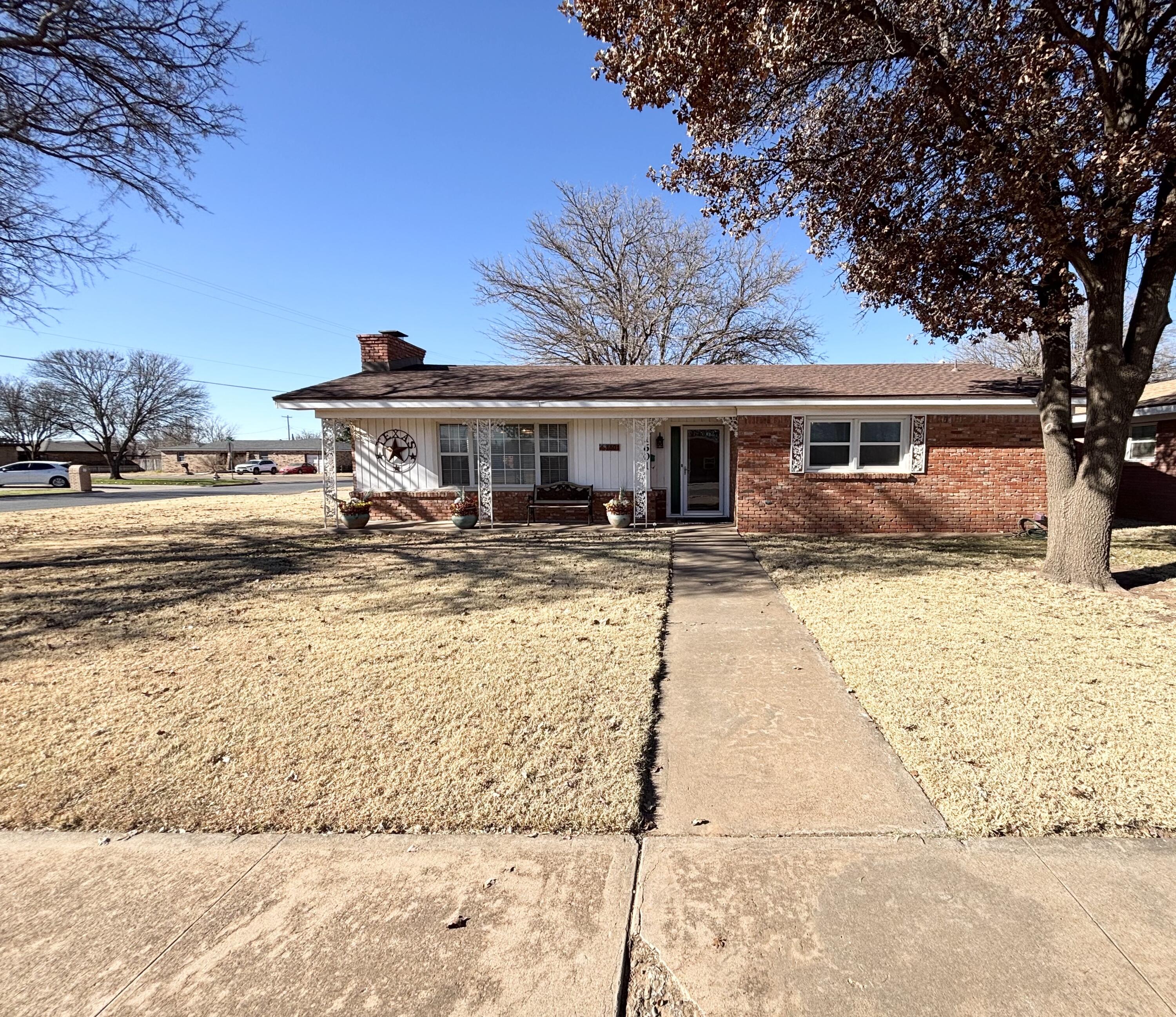 a front view of house with yard and trees around