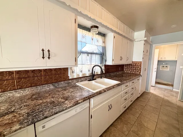 a large kitchen with kitchen island sink and cabinets
