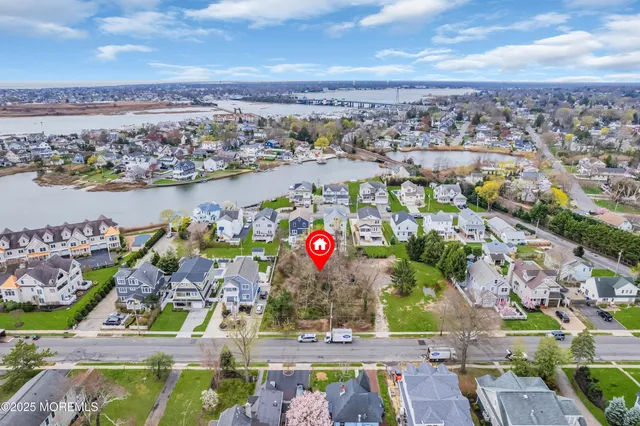 an aerial view of residential houses with outdoor space and lake view
