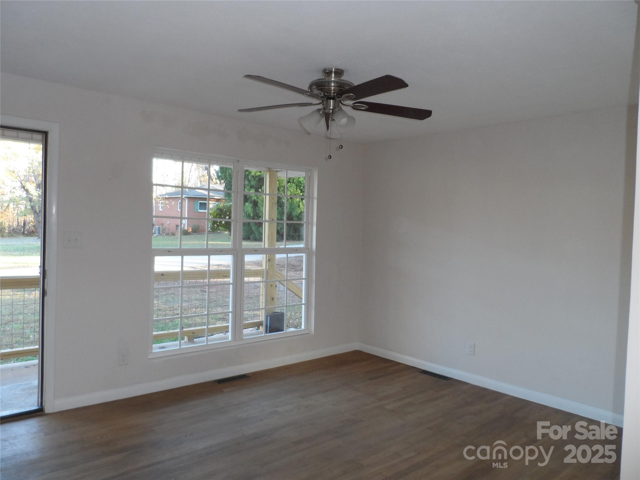 205 Phillips Street Morganton, NC 28655 - Photo 5 of 22 an empty room with wooden floor fan and windows