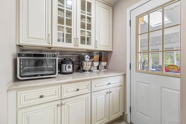 a kitchen with white cabinets and a window