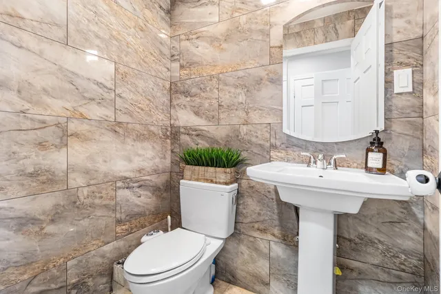 a bathroom with a sink a toilet and a mirror