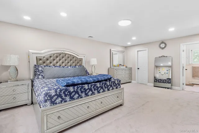 a bedroom with a large bed and a chandelier