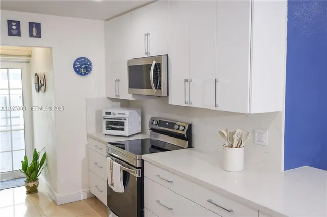 a kitchen with stainless steel appliances granite countertop a sink a stove and a microwave