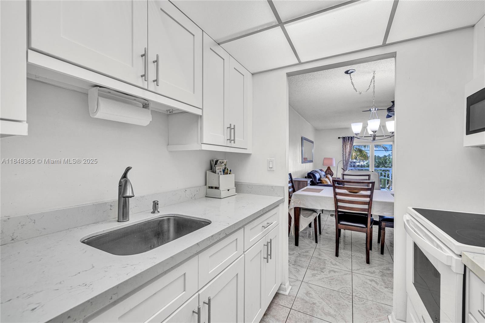 200 South Birch Road, Unit 201 Fort Lauderdale, FL 33316 - Photo 12 of 28 a kitchen with a sink cabinets and counter space