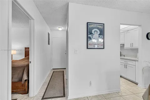 a view of kitchen with hallway and cabinets
