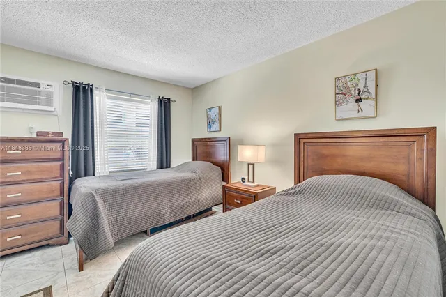a bedroom with two bed and a large window