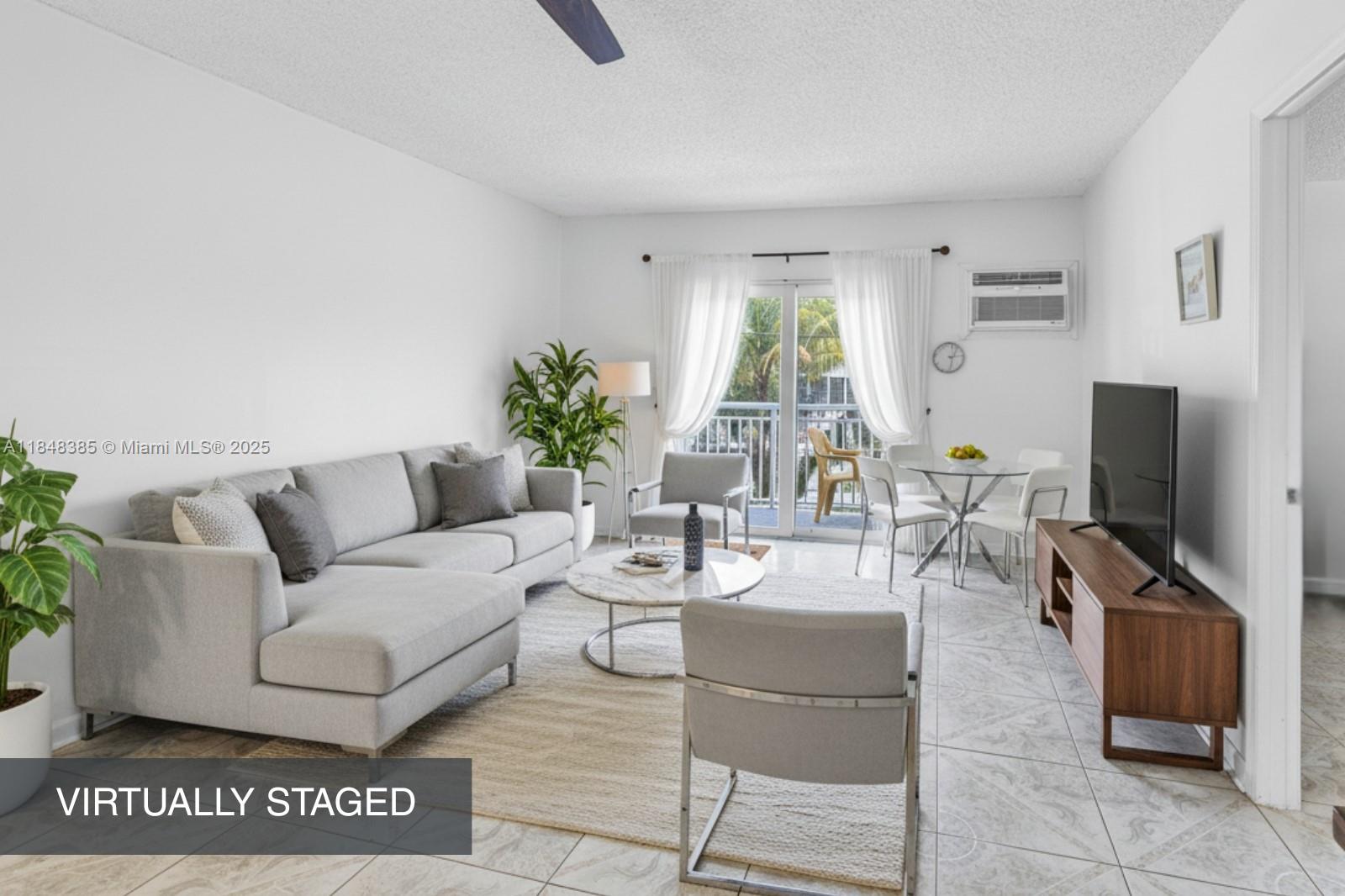 200 South Birch Road, Unit 201 Fort Lauderdale, FL 33316 - Photo 6 of 28 a living room with furniture a flat screen tv and a large window