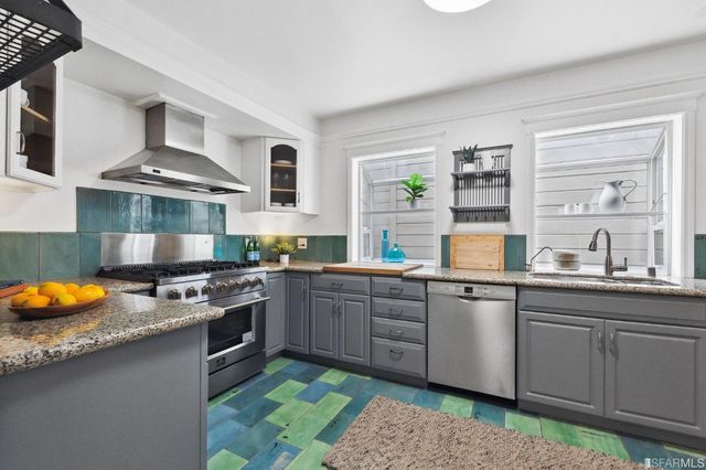 a kitchen with stainless steel appliances granite countertop a sink stove and cabinets