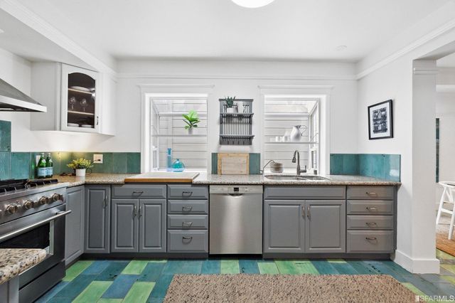 a kitchen with stainless steel appliances granite countertop a stove a sink and a granite counter tops with white cabinets