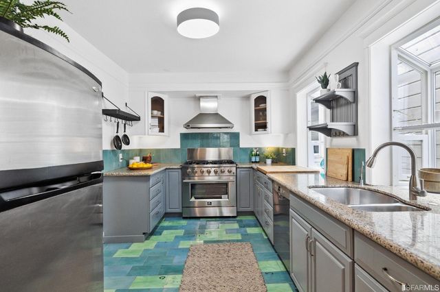 a kitchen with kitchen island granite countertop a sink stainless steel appliances and cabinets