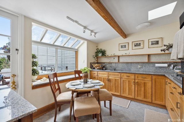 a kitchen with stainless steel appliances granite countertop a sink and a refrigerator