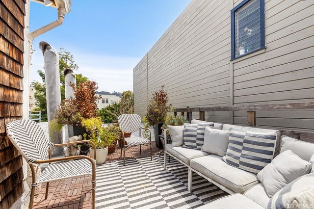 a view of a patio with a table and chairs and potted plants