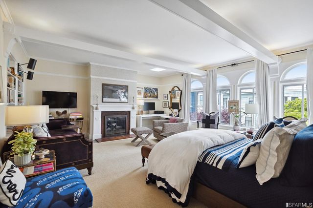 a spacious bedroom with a bed a couch and large windows