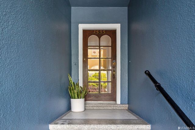 a front view of a house with a potted plant