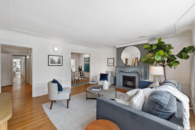 a living room with furniture fireplace and a potted plant