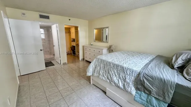 a bedroom with a bed and a refrigerator