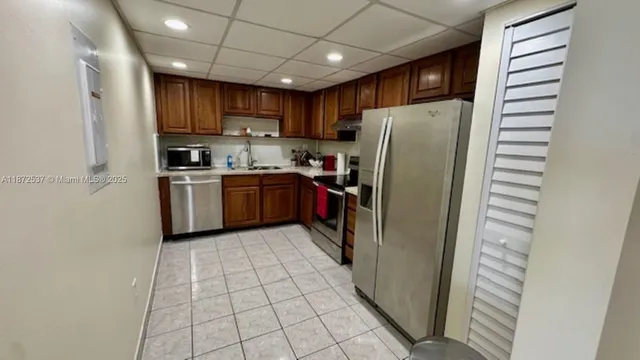a kitchen with stainless steel appliances granite countertop a refrigerator and a stove top oven