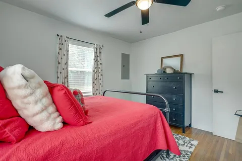 a bed sitting in a bedroom next to a window and a chandelier