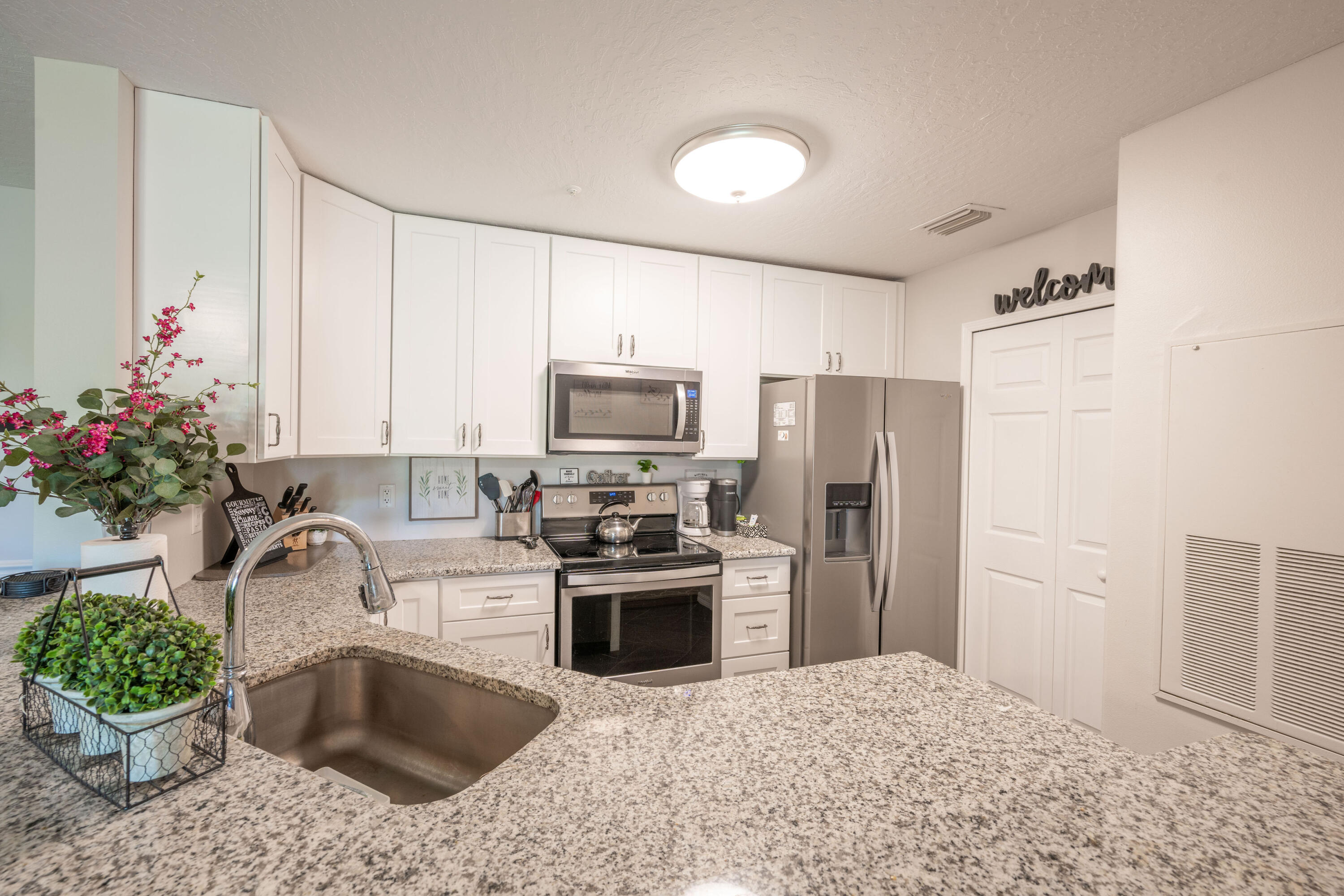 7667 North Wickham Road, Unit 1518 Melbourne, FL 32940 - Photo 3 of 32 a kitchen with granite countertop a sink stainless steel appliances and cabinets