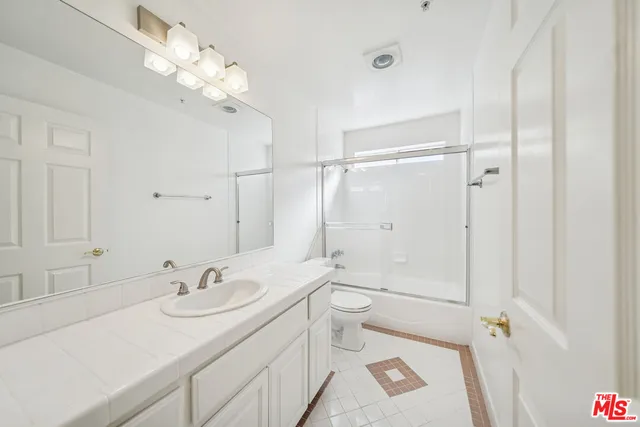 a bathroom with a shower a toilet and a tub