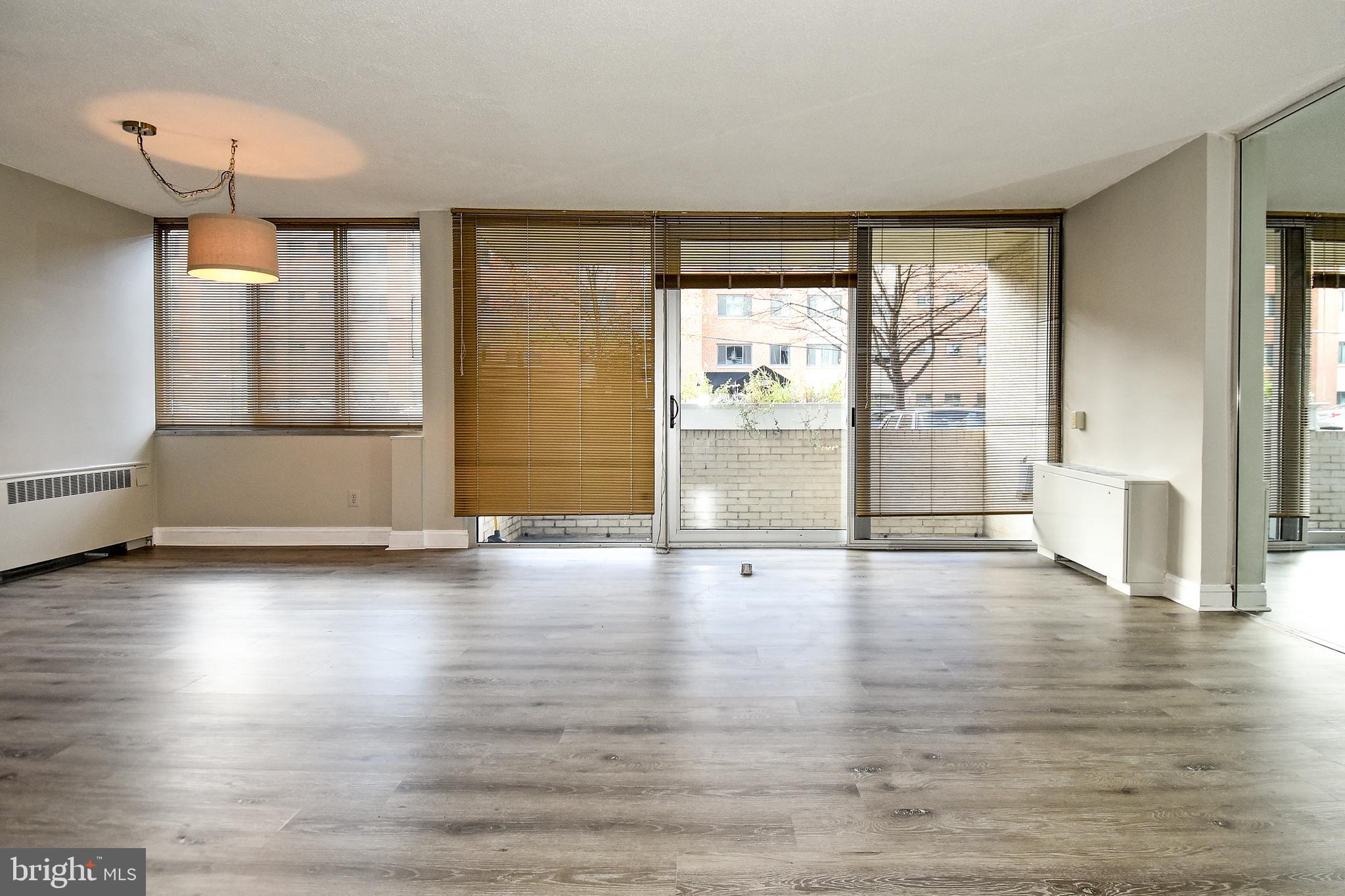 1301 South Arlington Ridge Road, Unit 110 Arlington, VA 22202 - Photo 3 of 45 a view of an empty room with wooden floor and a window