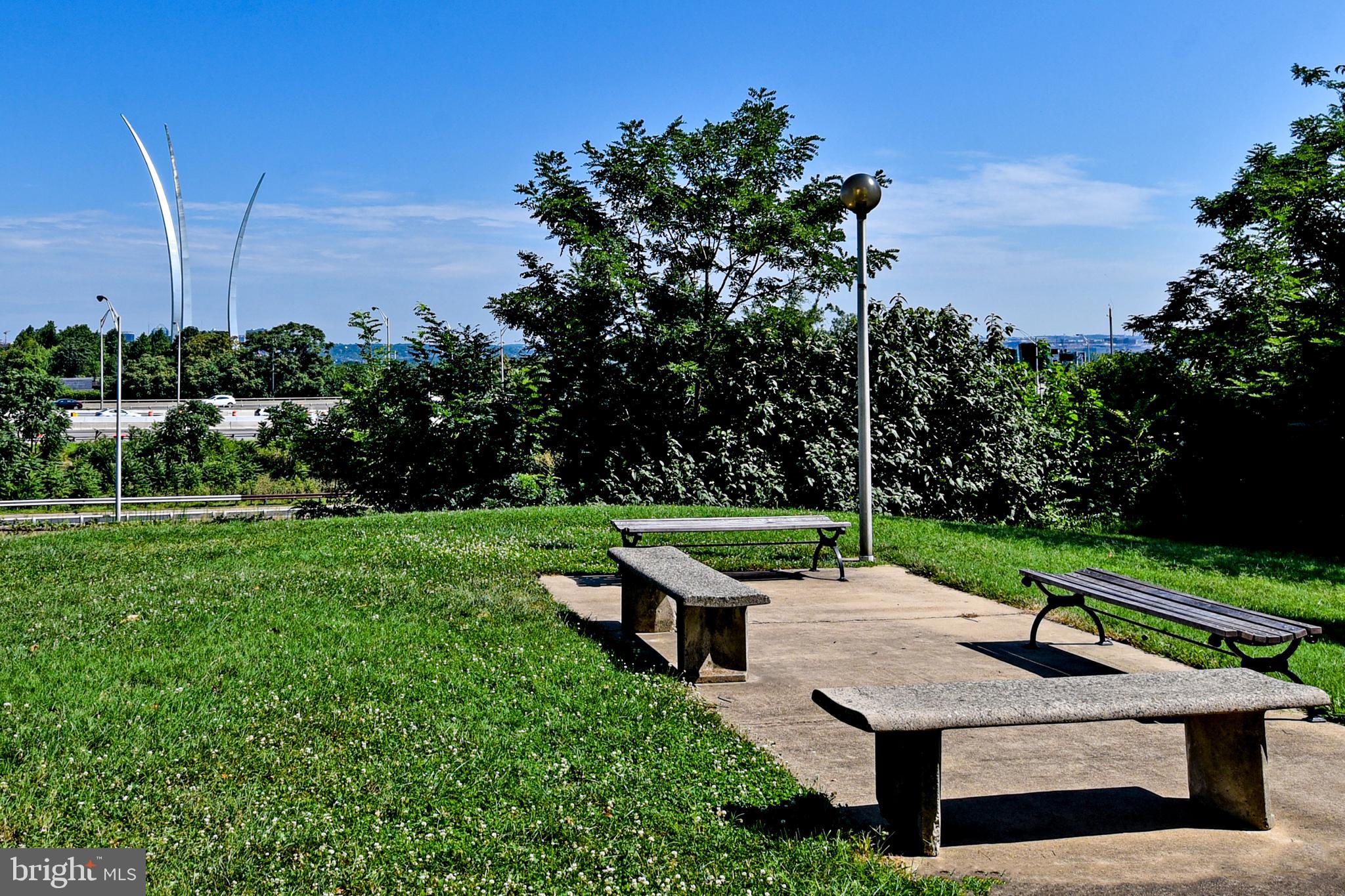 1301 South Arlington Ridge Road, Unit 110 Arlington, VA 22202 - Photo 33 of 45 a wooden bench sitting in a grassy field
