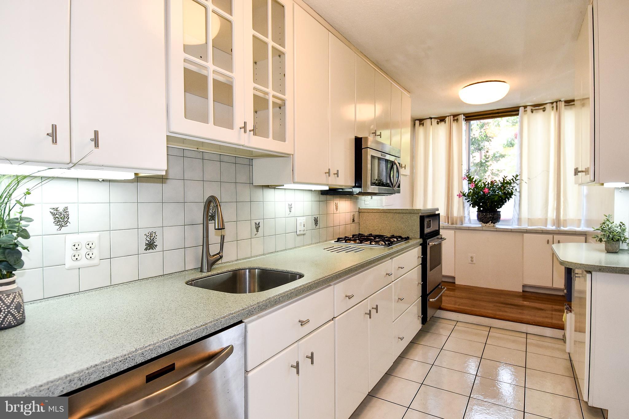 1301 South Arlington Ridge Road, Unit 110 Arlington, VA 22202 - Photo 7 of 45 a kitchen with granite countertop a sink stainless steel appliances and cabinets