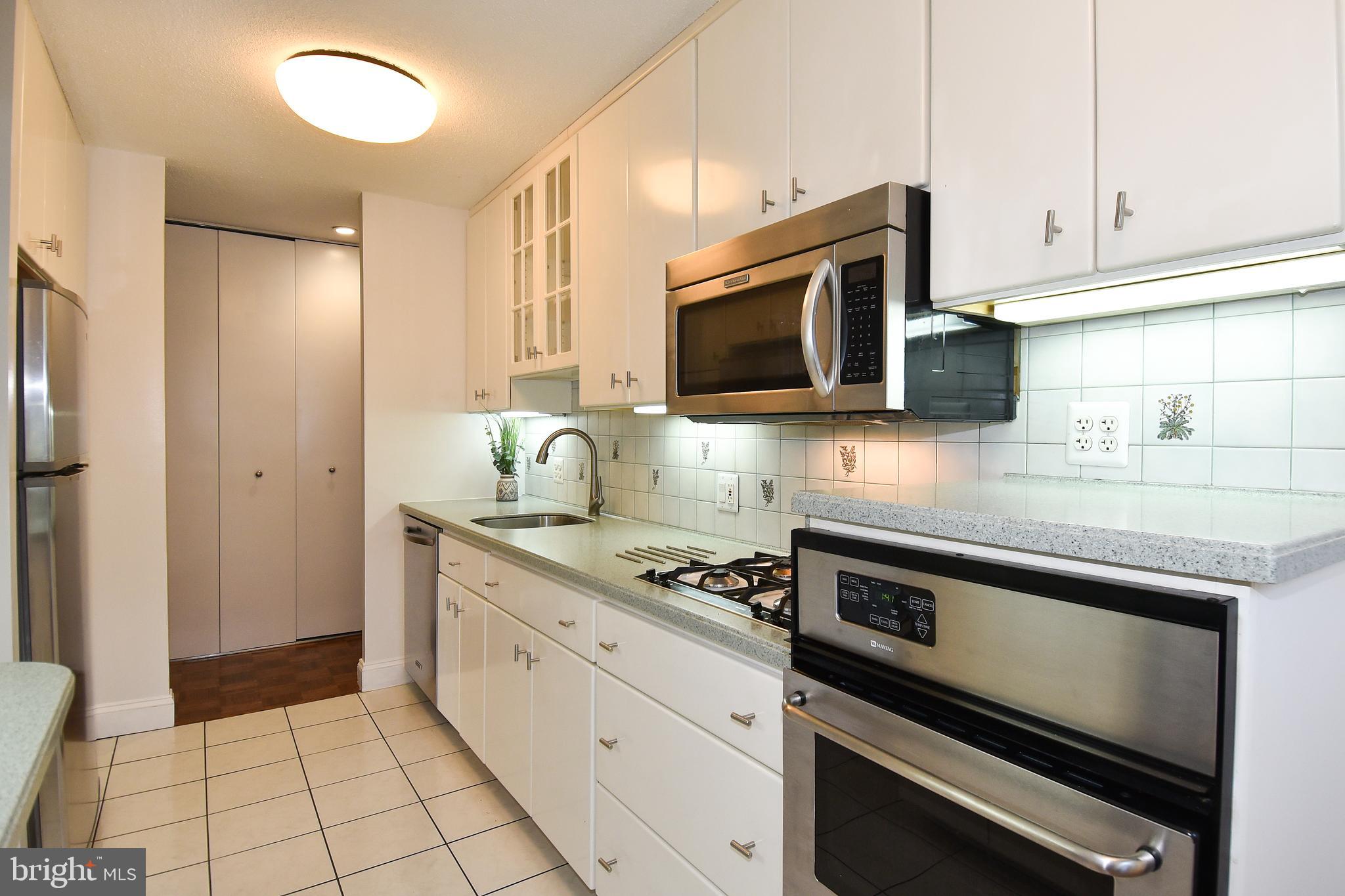 1301 South Arlington Ridge Road, Unit 110 Arlington, VA 22202 - Photo 8 of 45 a kitchen with granite countertop a stove microwave and sink