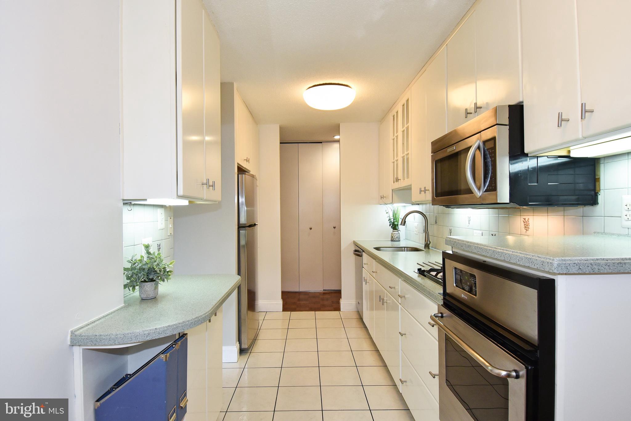 1301 South Arlington Ridge Road, Unit 110 Arlington, VA 22202 - Photo 9 of 45 a kitchen with stainless steel appliances granite countertop a sink and a stove