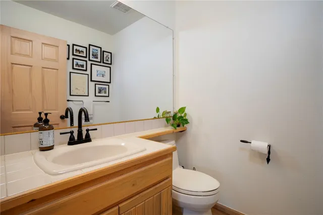 a bathroom with a sink a toilet and mirror