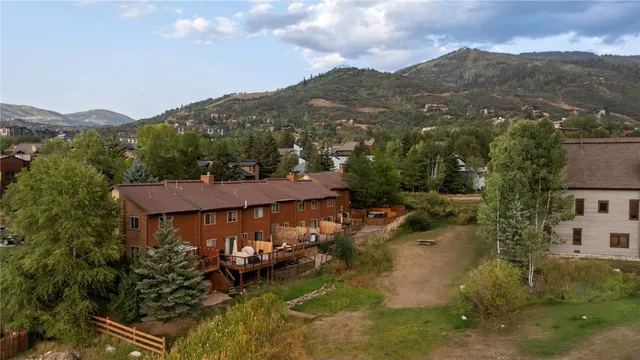 an aerial view of a house with a mountain in the background