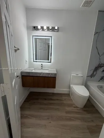 a bathroom with a double vanity sink toilet and a mirror