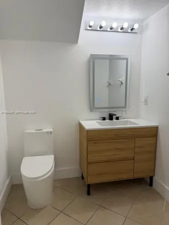 a bathroom with a toilet a sink and mirror